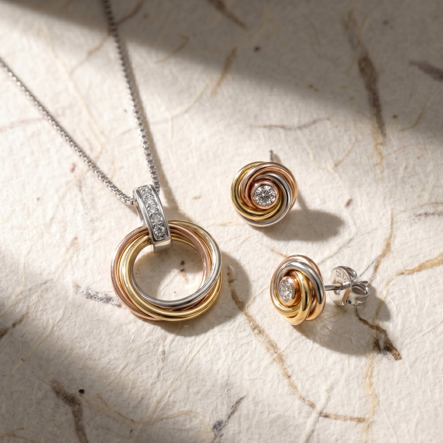 Pair of mixed vermeil gold and sterling silver earrings with intertwined love knot design, each set with a sparkling lab grown diamond for elegant fine jewellery.