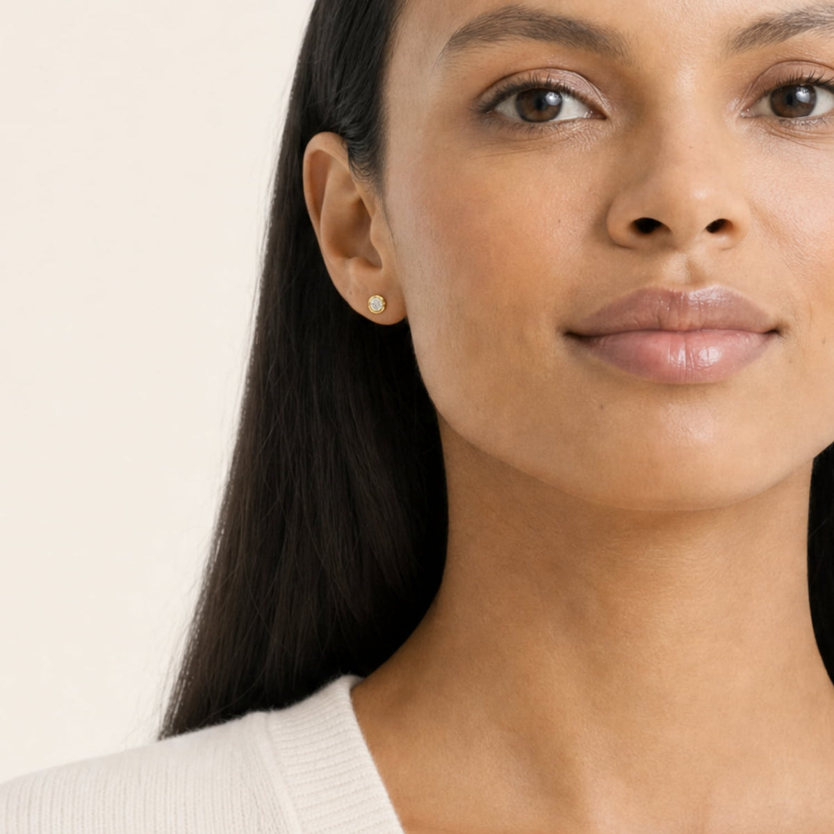 A model wears gold vermeil stud earrings featuring lab grown diamonds in a smooth bezel setting, showcasing refined and timeless silver jewellery design.