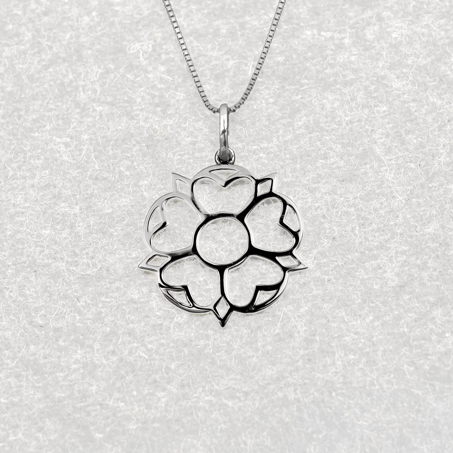 Sterling silver pendant featuring an openwork Yorkshire rose motif with a polished finish, hanging from a delicate fine chain for refined contemporary silver jewellery.