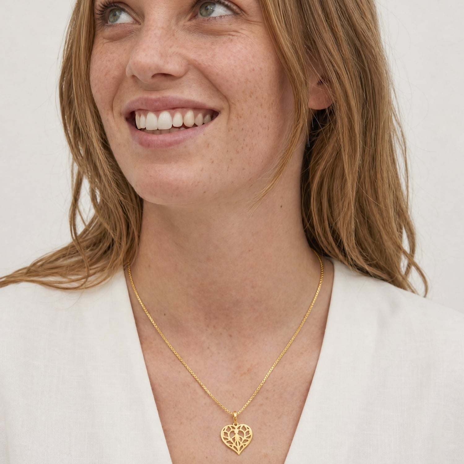 Delicate gold vermeil necklace featuring a miniature openwork heart pendant inspired by Yorkshire, suspended on a fine chain, styled with a neutral white top.