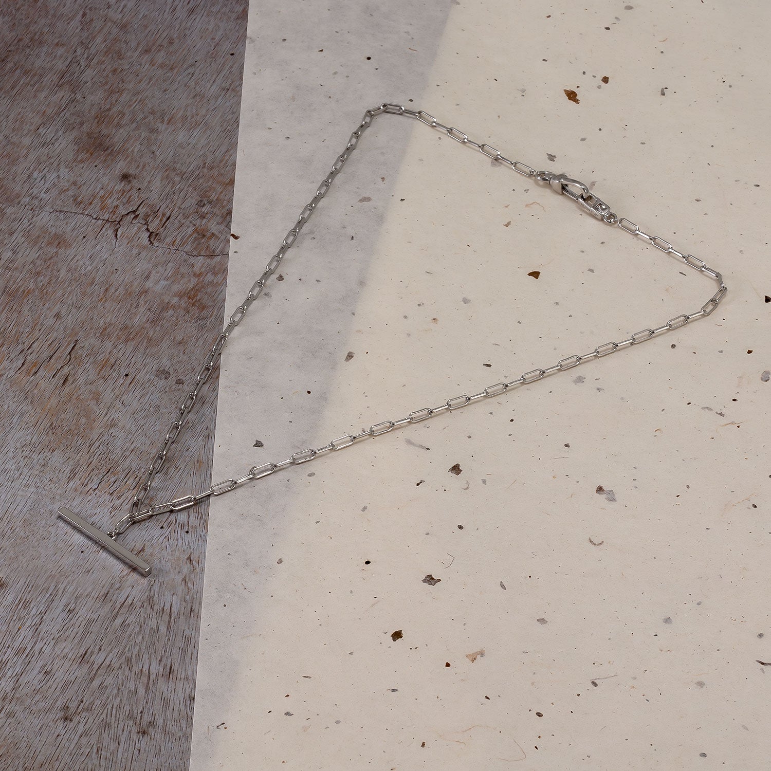 Sterling silver necklace featuring a distinguished T-bar fob and clip clasp, showcasing a sleek, minimalist chain design with a sculptural, contemporary aesthetic.