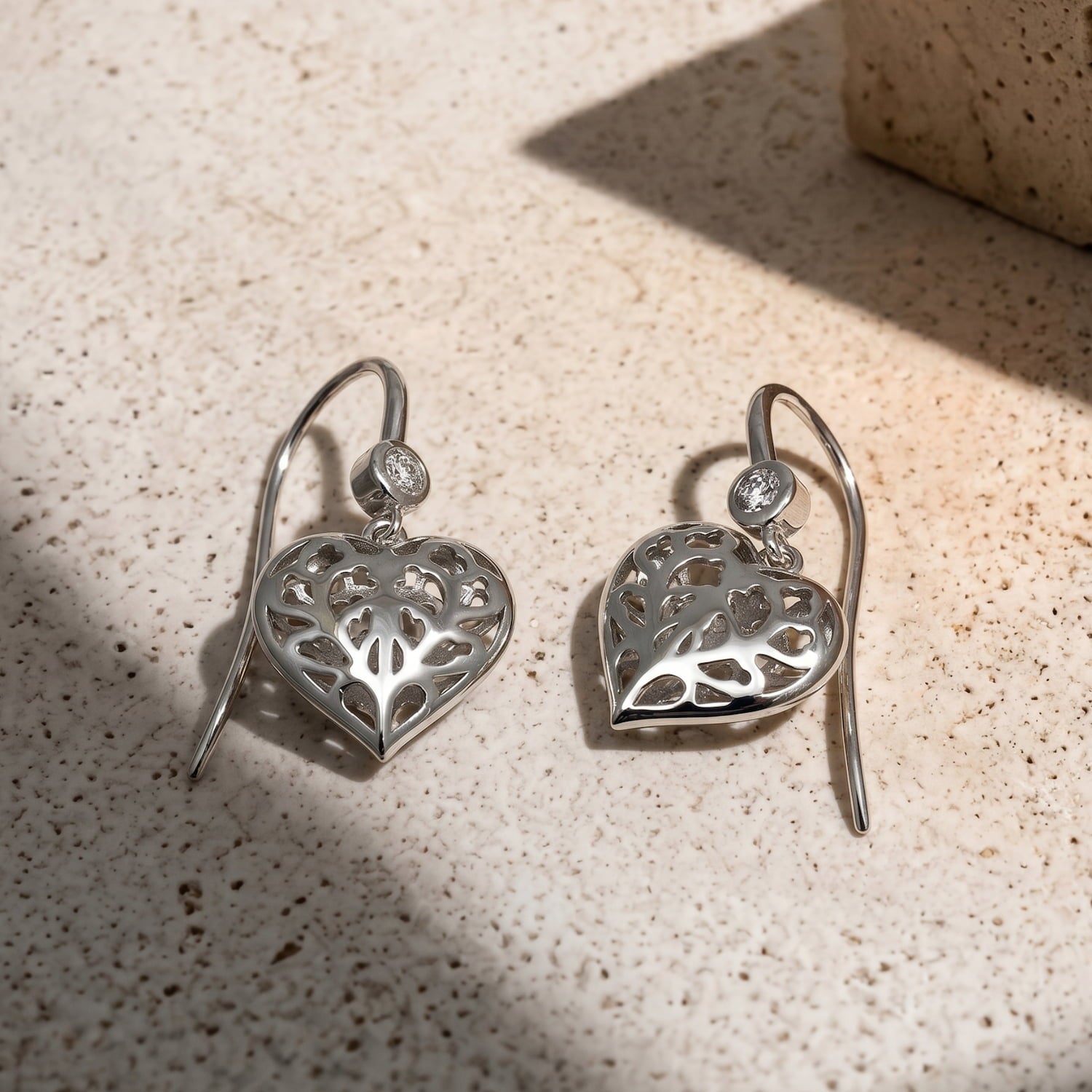 Pair of Lab grown diamond and sterling silver drop earrings featuring delicate, sculptural hanging hearts with intricate cut-out detailing, designed for elegant everyday wear.