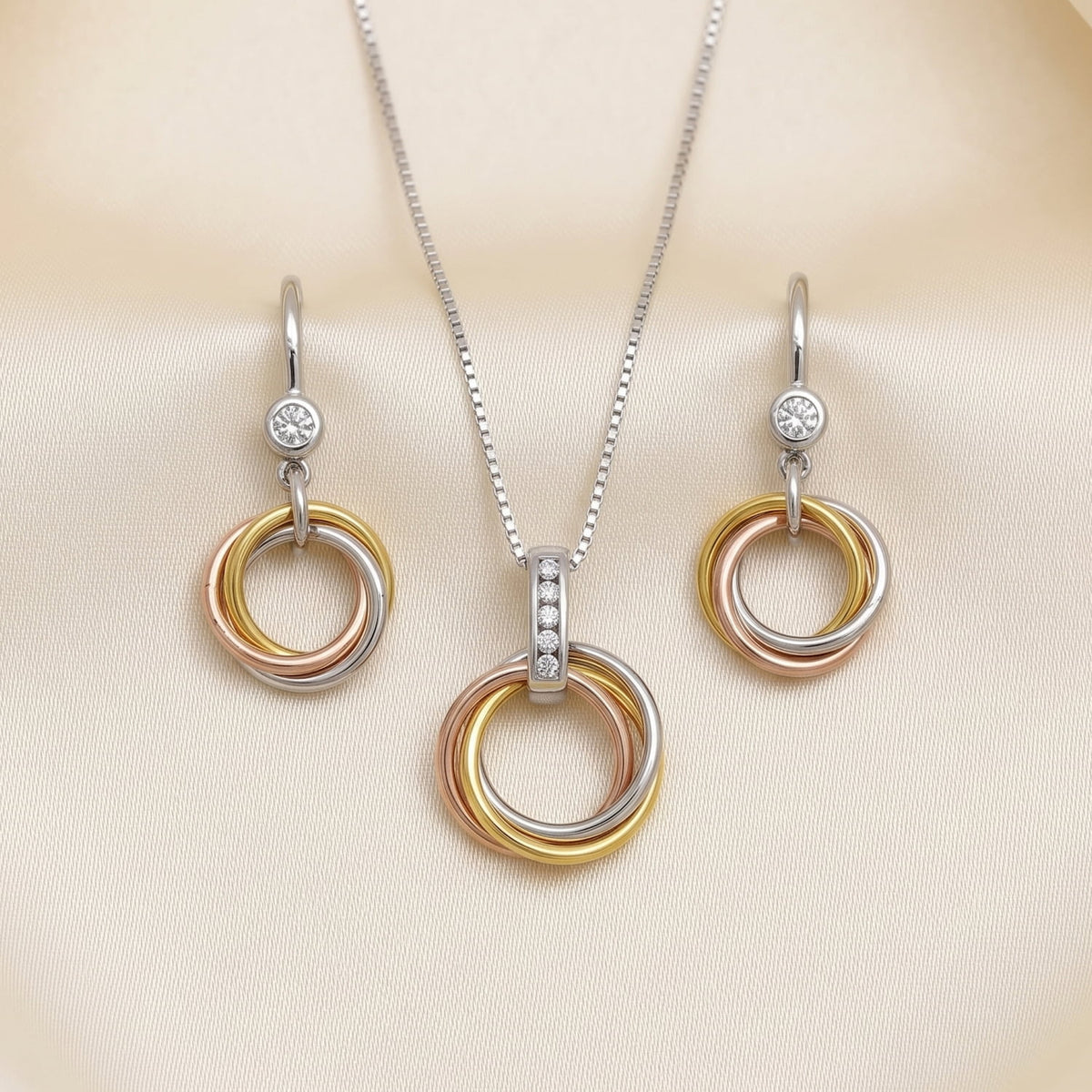 Set of intertwined gold vermeil hoop drop earrings and matching pendant necklace, each featuring sparkling lab grown diamonds and a polished sterling silver chain.