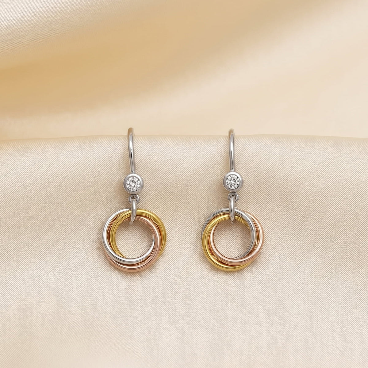 Delicate drop earrings featuring intertwined mixed vermeil circles with a sparkling 0.15 carat lab-grown diamond accent, showcasing contemporary sterling silver design.