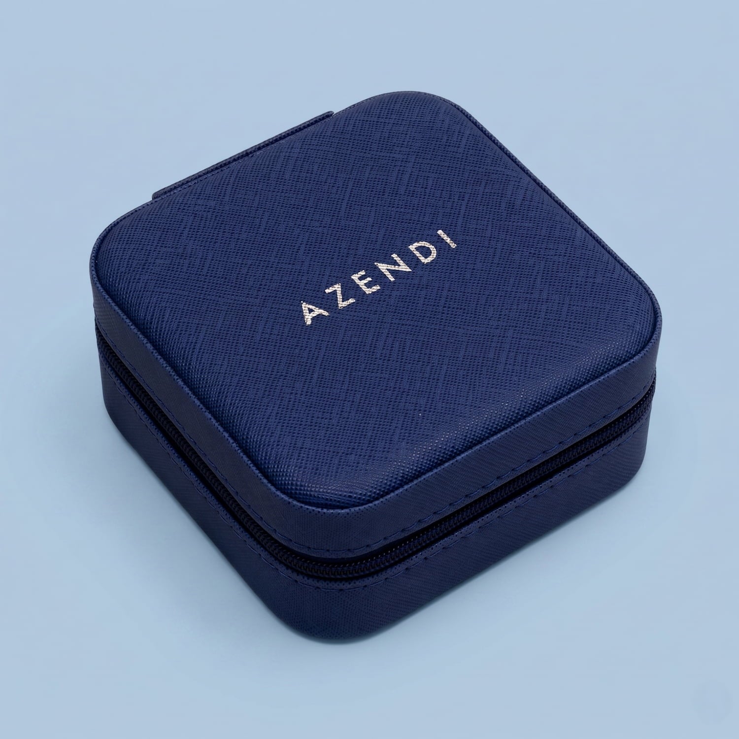 Navy blue jewellery box with 'AZENDI' branding on a light blue background