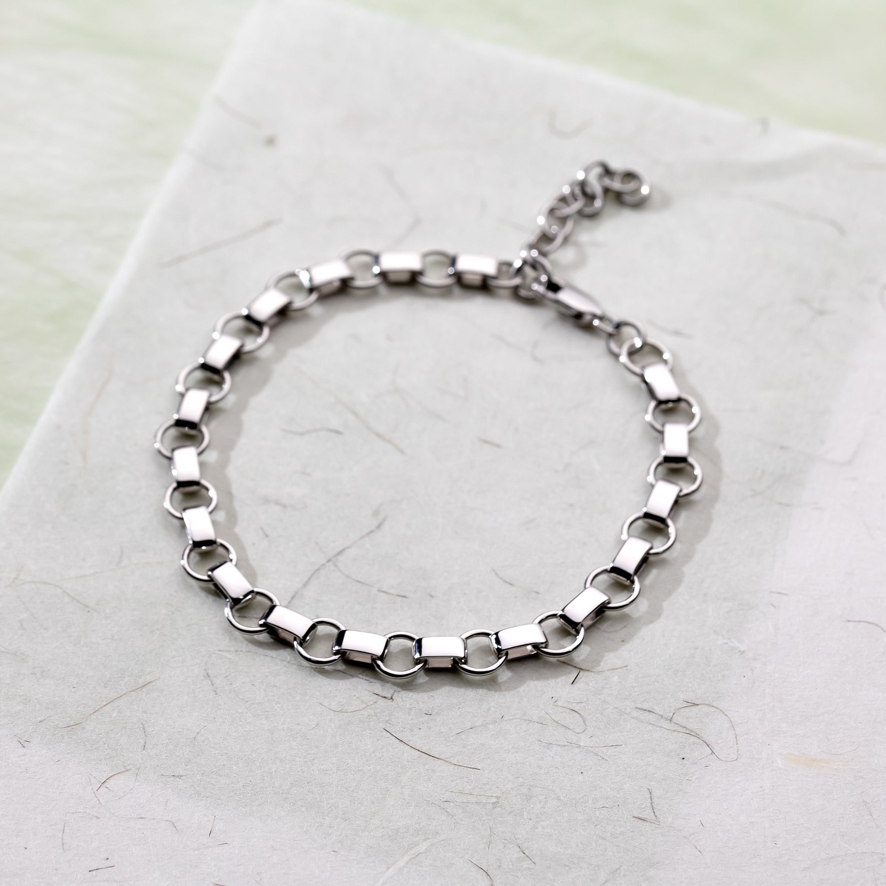 Sterling silver bracelet featuring alternating circle and flat oval links, creating a modern sculptural chain design with adjustable length for versatile wear.