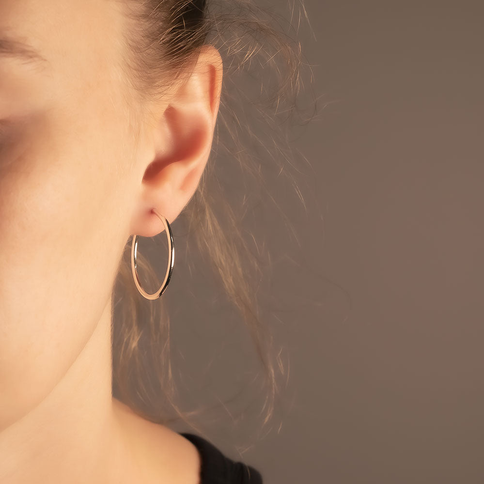 Elegantly simple 3cm diameter silver hoop earrings featuring a polished finish, exemplifying refined British sterling silver jewellery by Azendi.
