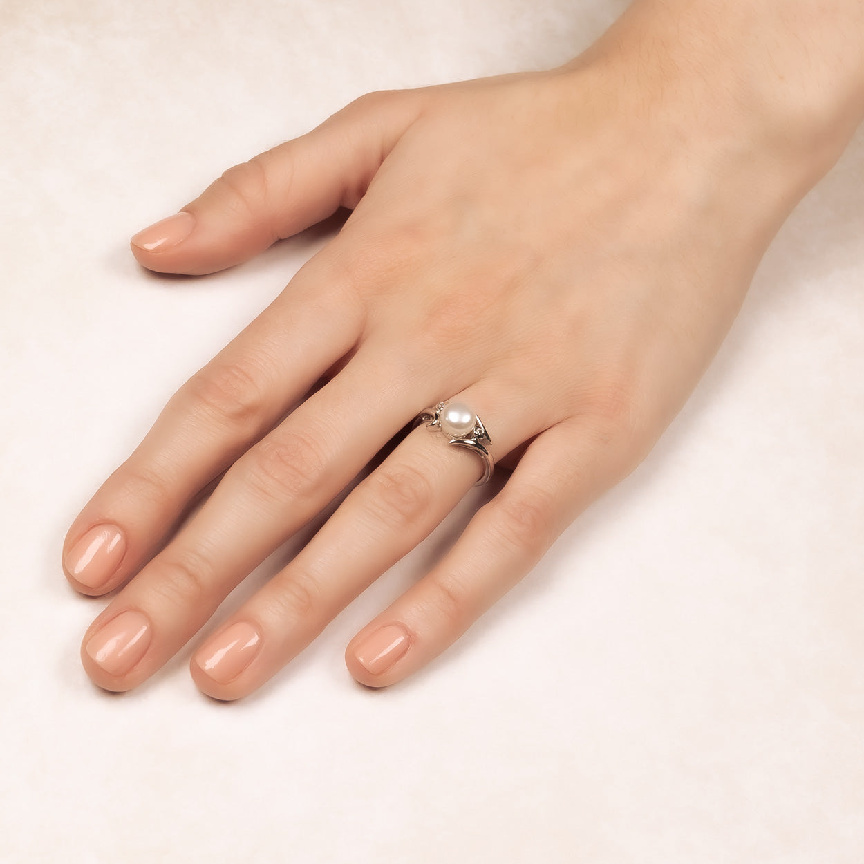 Elegant sterling silver ring featuring a single freshwater pearl with a gently curving band, showcasing a refined and sculptural design by Azendi.