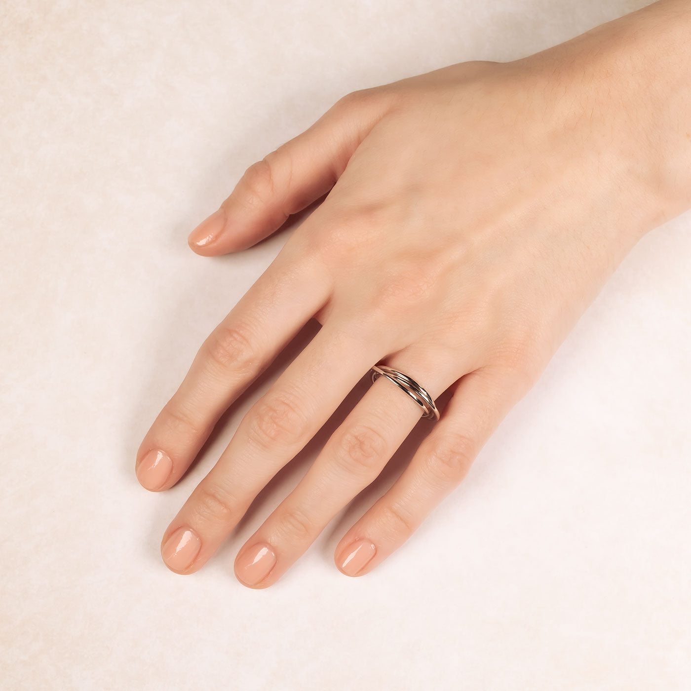 Sterling silver Russian wedding ring with a smooth, polished finish and subtle sculptural details, shown worn on a hand for an elegant contemporary jewellery look.