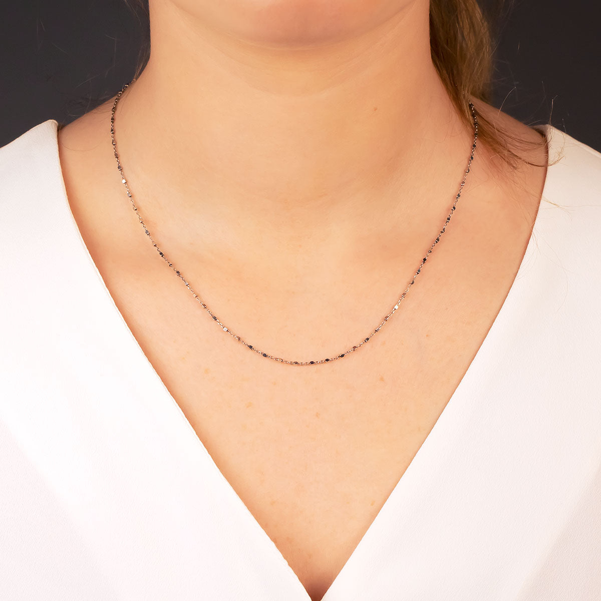 Delicate sterling silver layering necklace featuring a fine chain accented with small cubes, showcasing minimalist sculptural design by Azendi in contemporary silver jewellery.