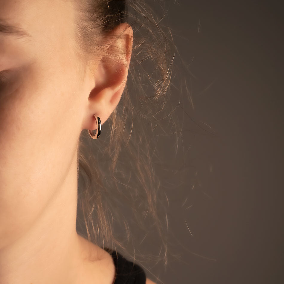 Medium-sized sterling silver rounded hoop earring with a smooth polished finish, showcasing a minimalist and refined design in contemporary silver jewellery.