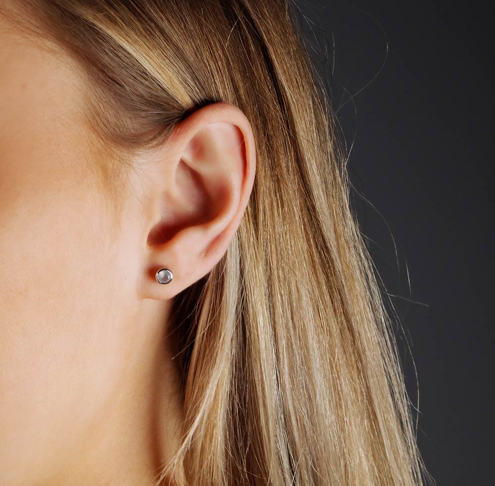 Delicate sterling silver stud earrings featuring smooth aqua chalcedony gemstones, showcasing a minimalist and elegant design crafted by an award-winning British jeweller.