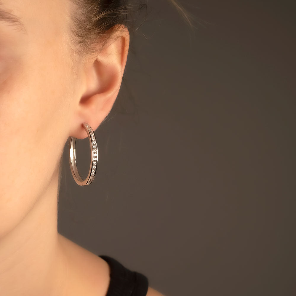 Large sterling silver hoop earrings featuring a hinged design with a row of polished stones set along the front, combining sculptural elegance with contemporary British silver jewellery.