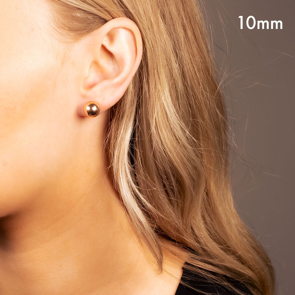 Rose gold vermeil ball sphere stud earring with a smooth polished finish, worn on the earlobe for a refined and minimalist look in contemporary sterling silver jewellery.