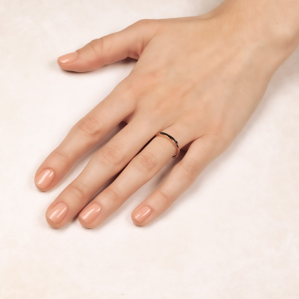 Hand wearing a sleek rose gold vermeil bar ring with a slender band, showcasing refined minimalist design in contemporary sterling silver jewellery by Azendi.