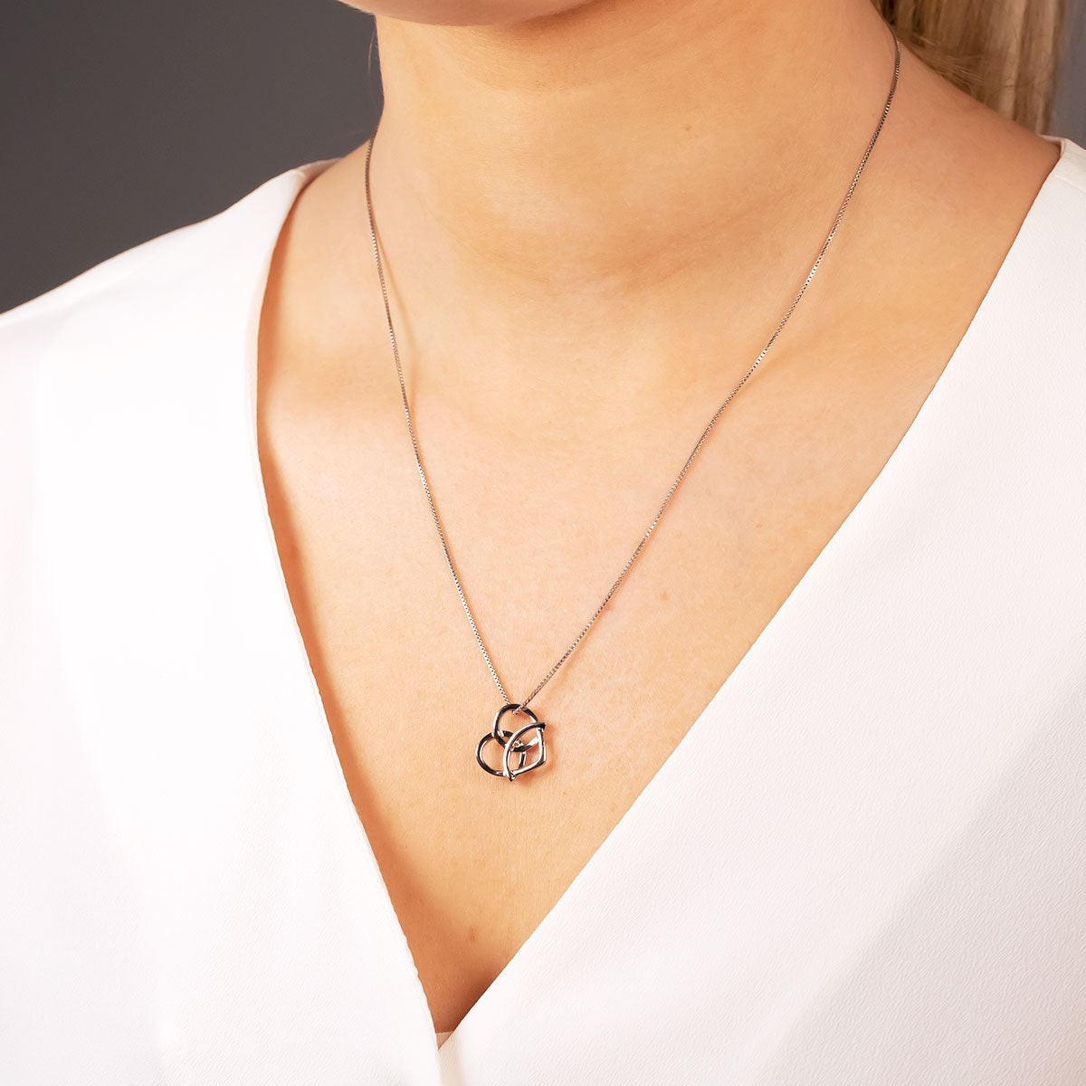 Sterling silver pendant featuring an intertwined Celtic trinity heart design on a fine chain, showcasing a refined and sculptural silver jewellery piece by Azendi.