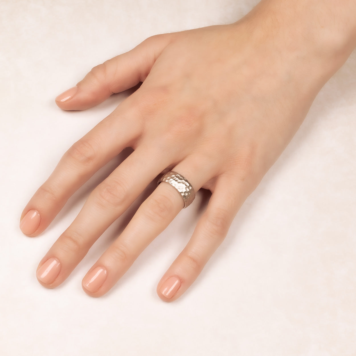 Sterling silver ring with a satin finish and hammered texture, showcasing a sculptural design on a hand for a refined and modern silver jewellery look.