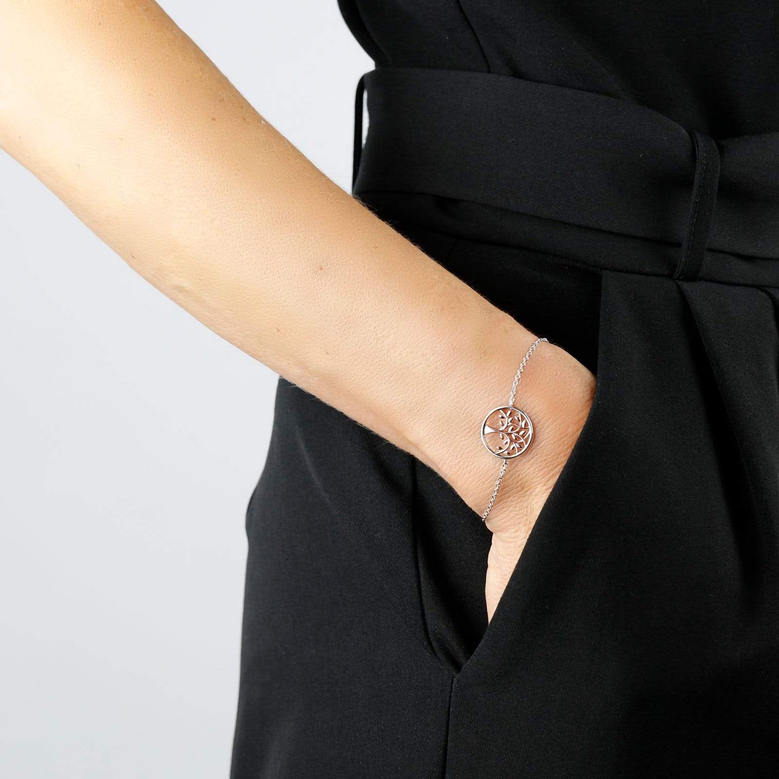 Delicate silver bracelet featuring a sculptural circular charm with a tree motif, worn on the wrist with a fine chain, highlighting contemporary sterling silver jewellery design.