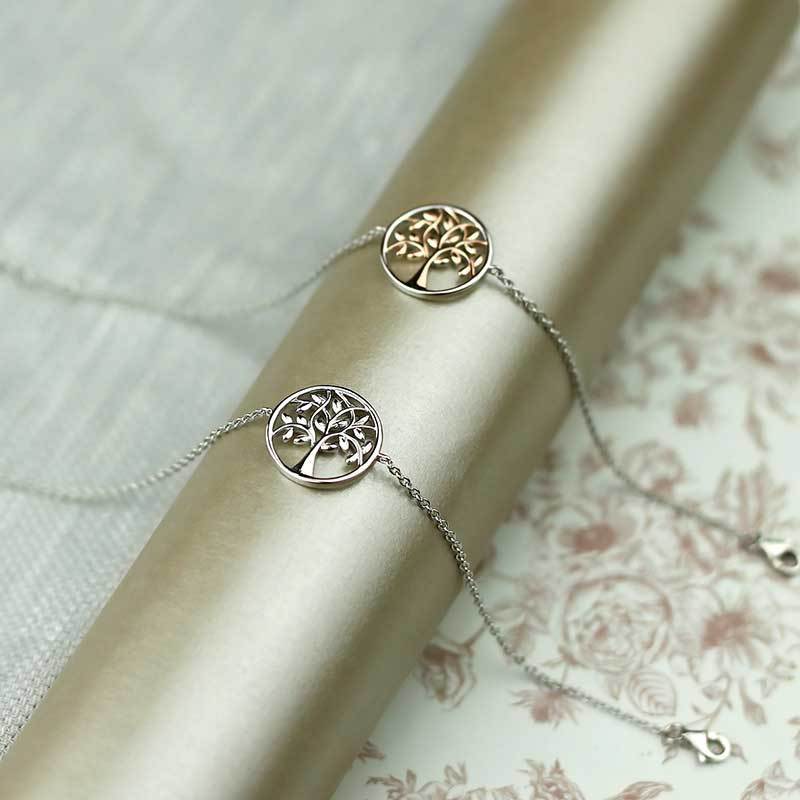 Two delicate bracelets featuring round pendants with intricate tree of life designs, crafted in sterling silver and rose gold vermeil, displayed on a soft neutral background.