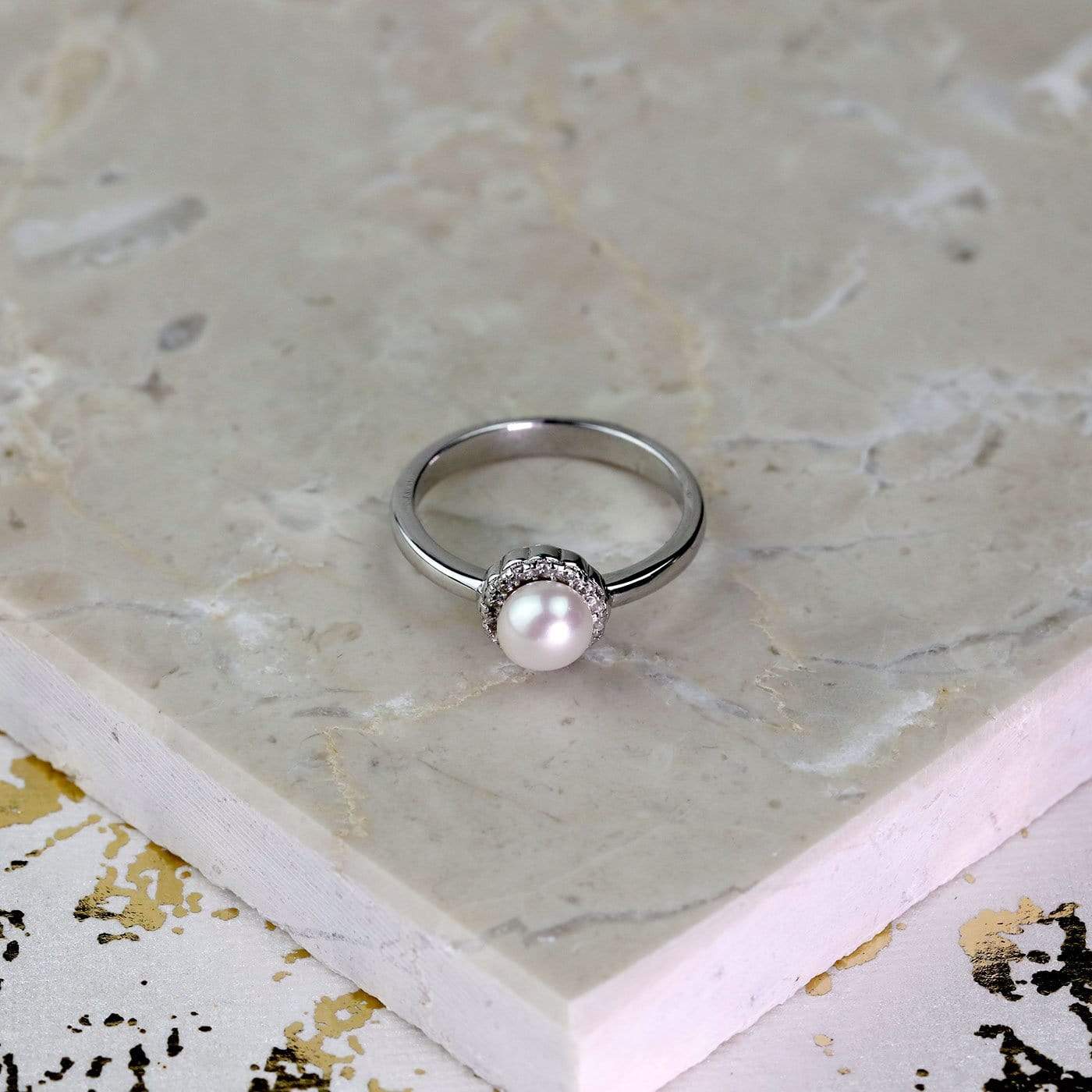 Sterling silver ring featuring a central freshwater pearl surrounded by sparkling cubic zirconia stones, showcasing a refined and sculptural design by Azendi.