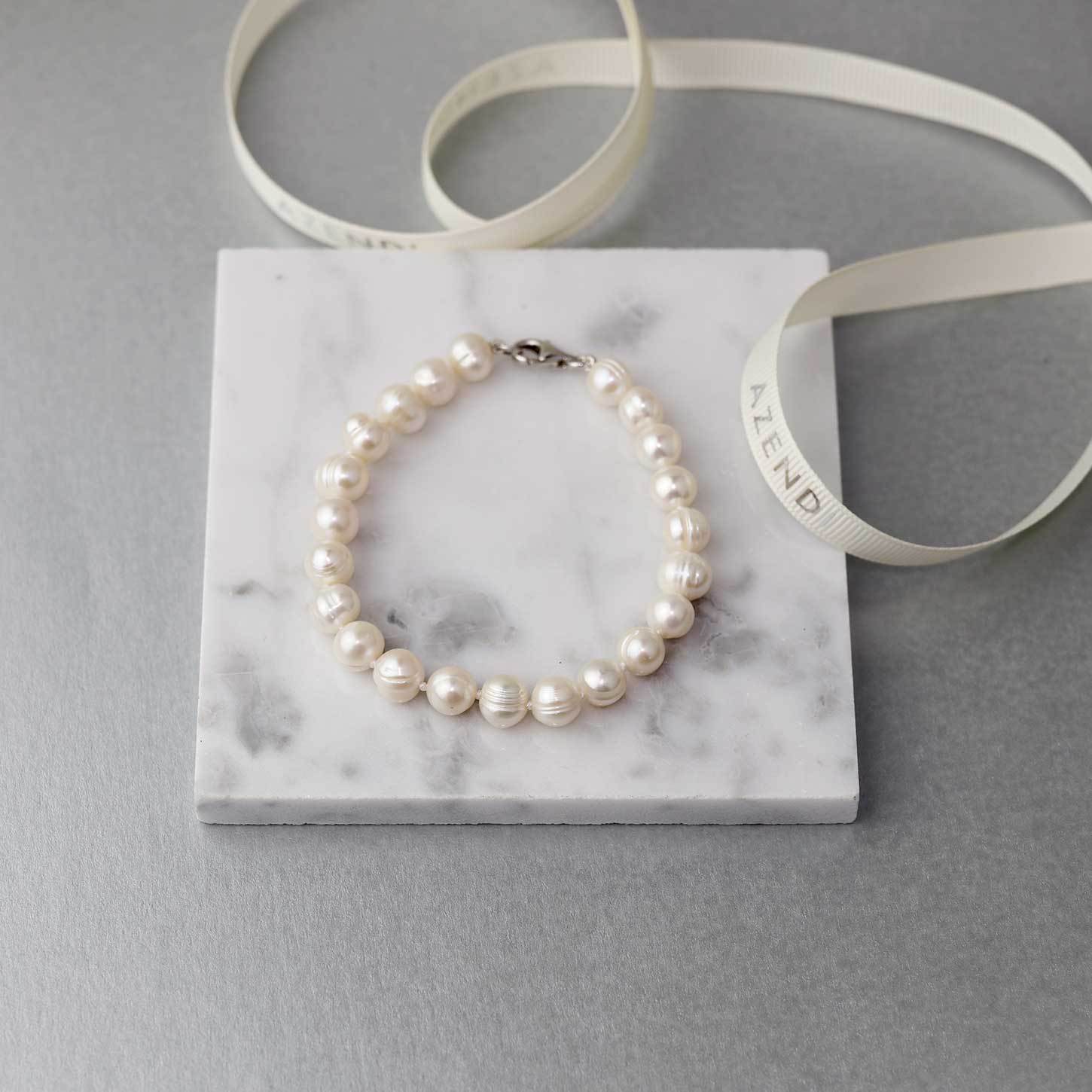 Elegant freshwater pearl bracelet featuring uniform 8mm pearls strung on a sterling silver clasp, exemplifying refined and contemporary silver jewellery by Azendi.