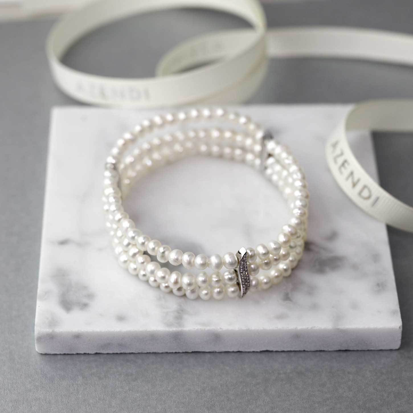 Triple strand bracelet featuring lustrous pearls accented by a sculptural sterling silver pavé wave clasp, showcasing elegant and contemporary silver jewellery design by Azendi.