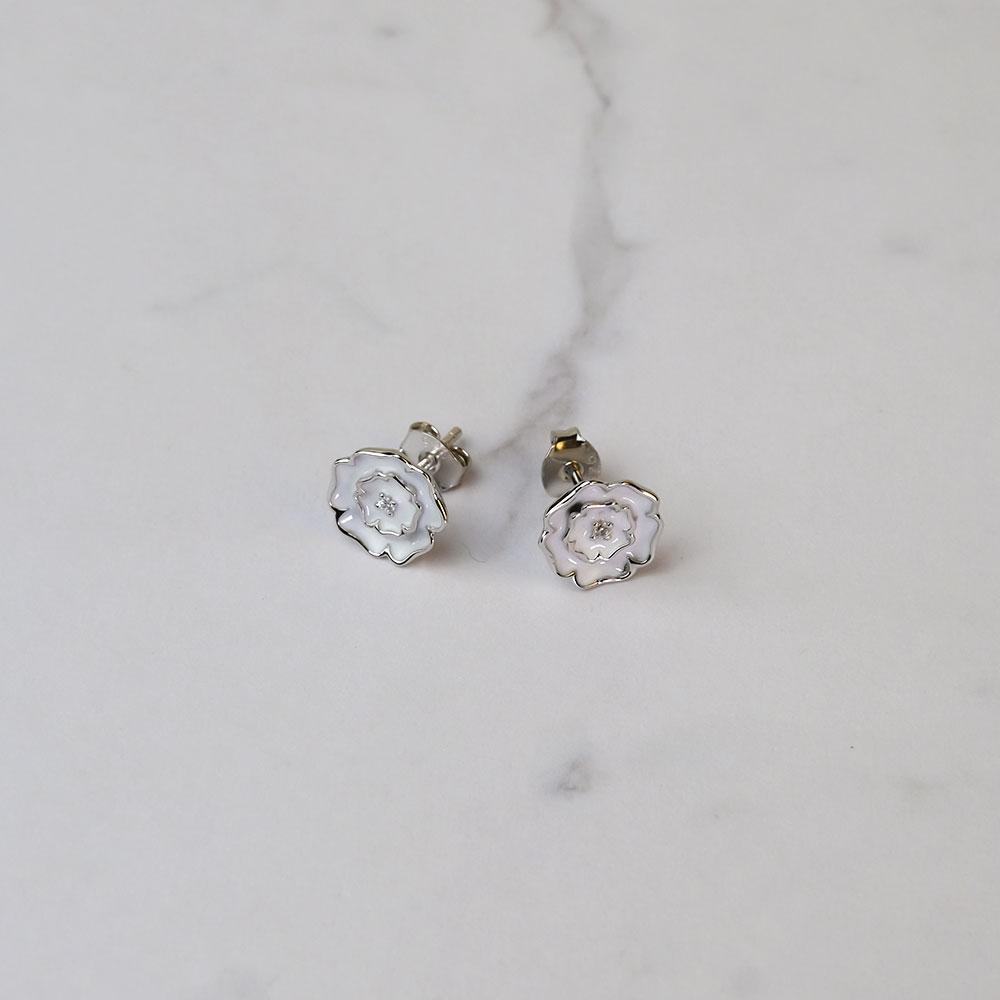 Pair of sterling silver stud earrings shaped as Yorkshire roses, featuring delicate white enamel detailing and a polished finish for a refined, sculptural look.