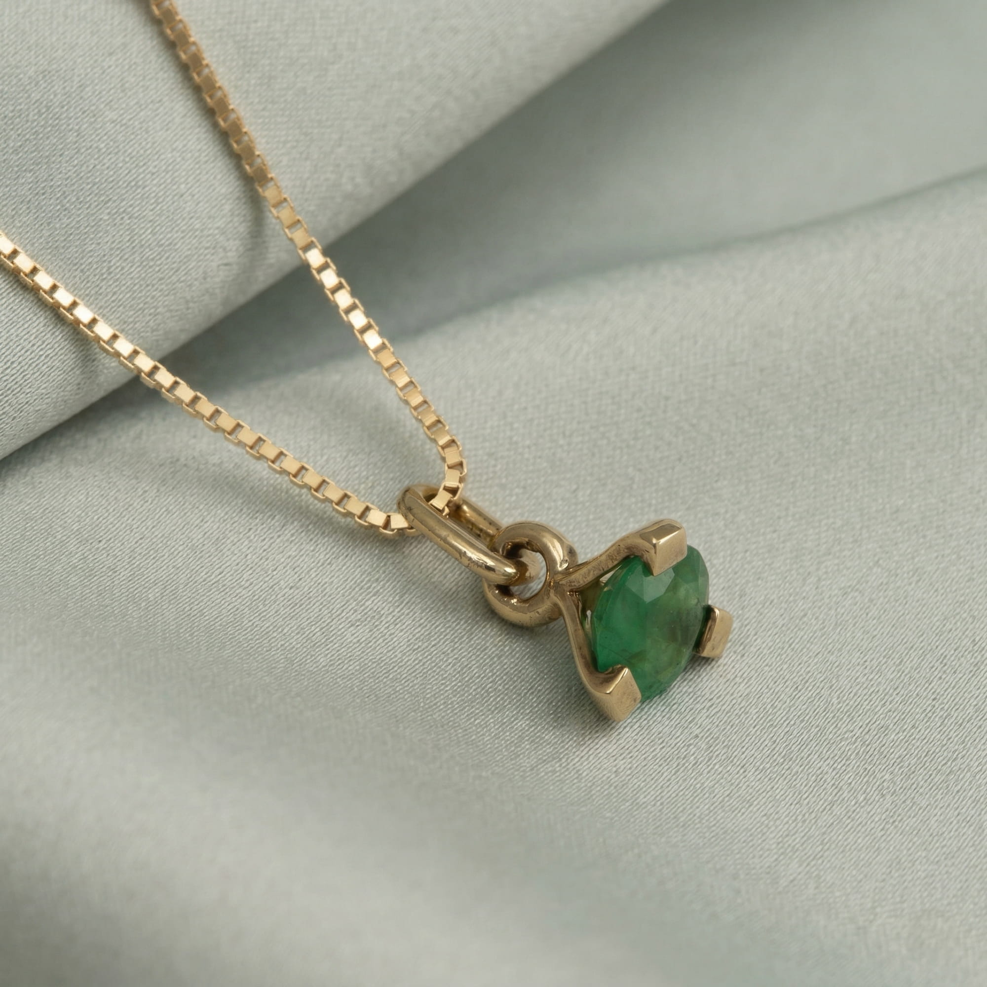Yellow gold vermeil pendant necklace featuring a vibrant green emerald gemstone set in a sleek, contemporary design on a delicate box chain.