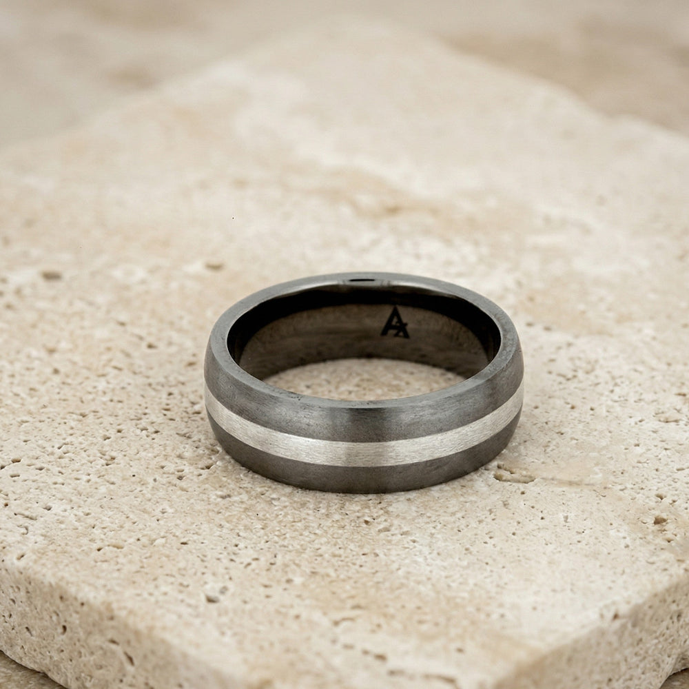Wide band court ring crafted from titanium featuring a striking silver stripe detail, showcasing a contemporary and sculptural design in men's silver jewellery.