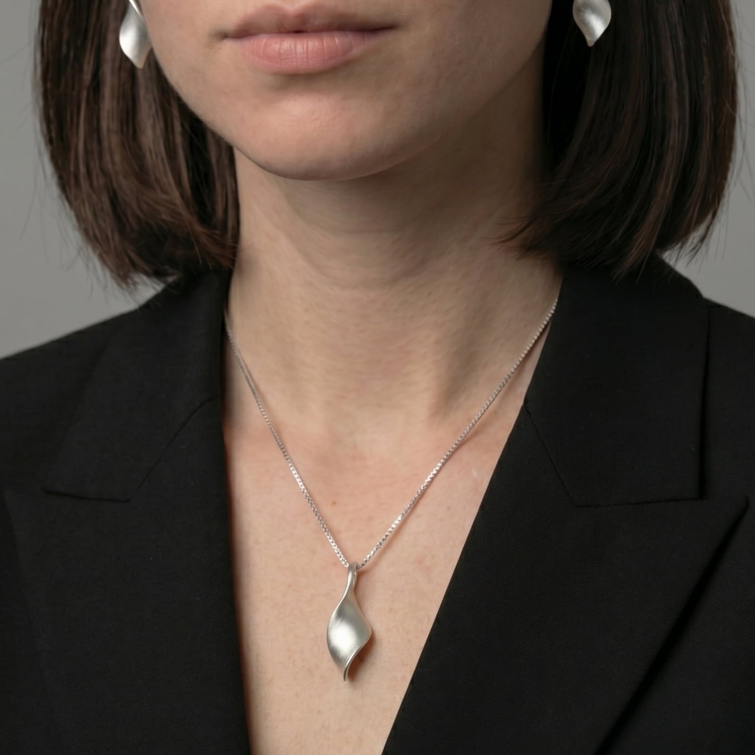 Woman wearing a silver twisting pendant