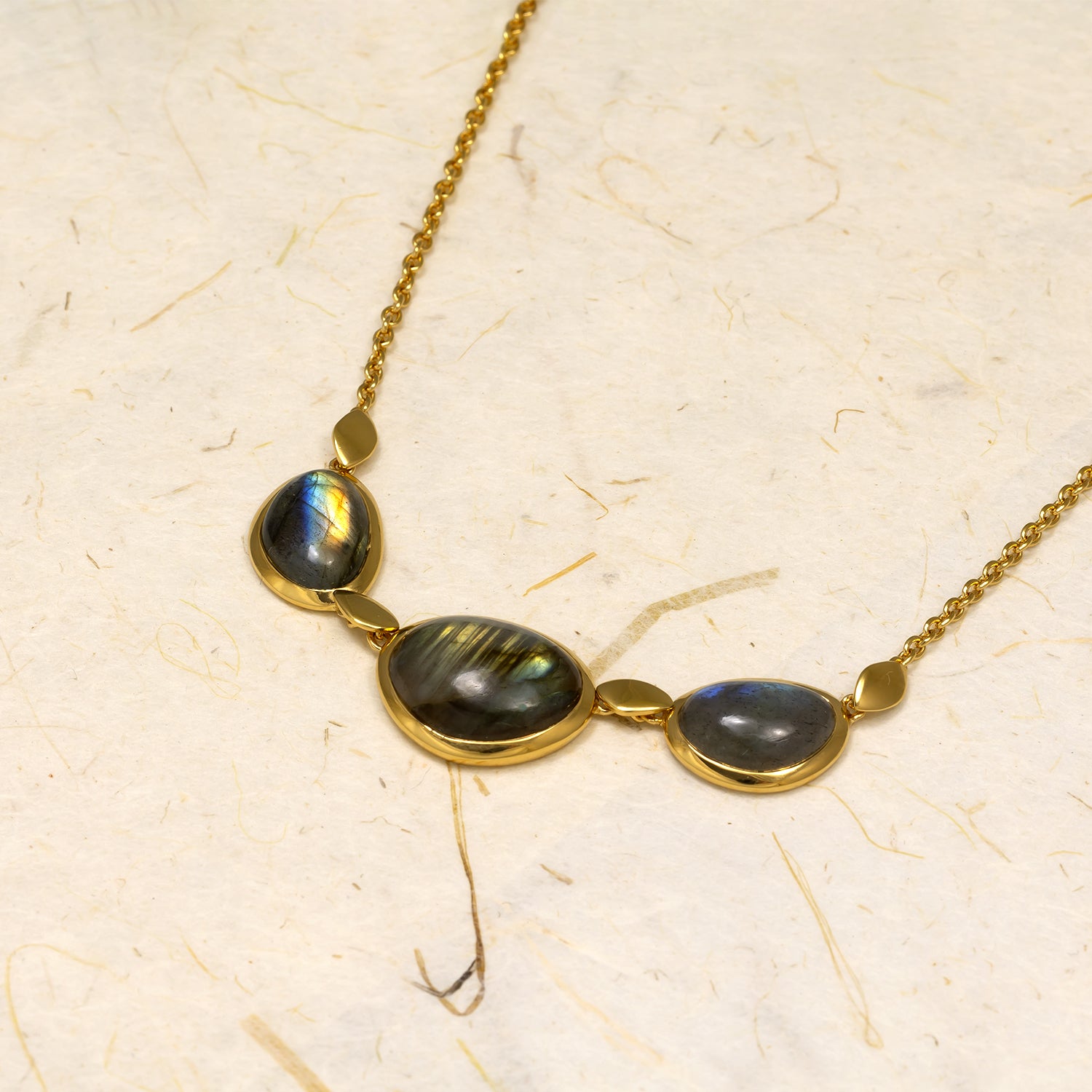 Adjustable gold vermeil necklace featuring three polished Spectrolite stones in varying shapes, designed with a sleek chain for a modern, elegant look.
