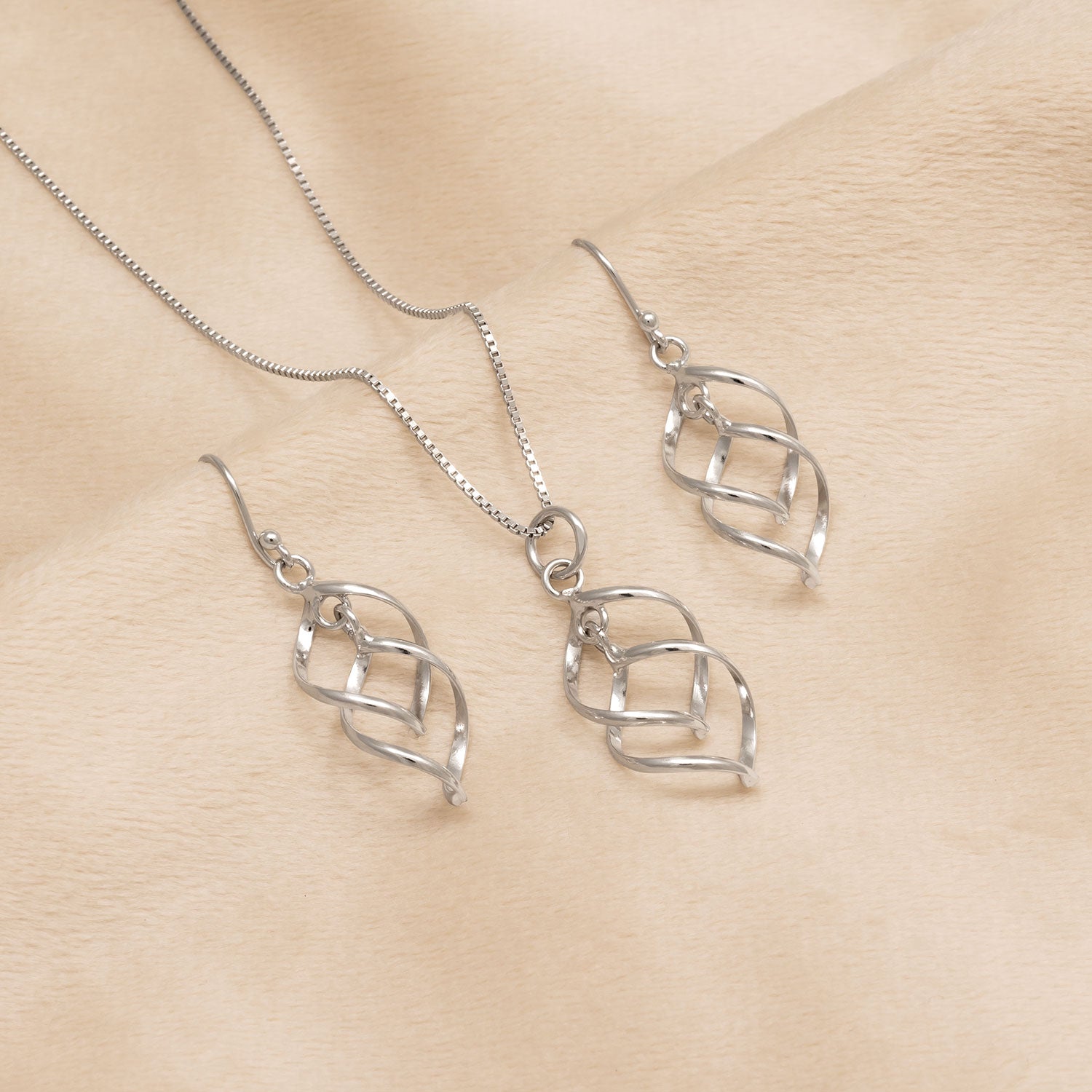 Spiral Waves Drop Earrings - Silver displayed alongside a matching pendant necklace, both featuring intertwined wave designs in polished silver sterling jewellery.