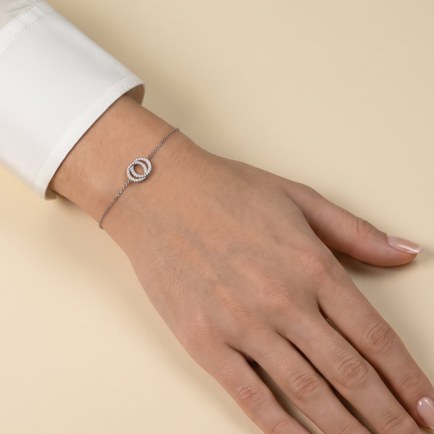 Delicate sterling silver bracelet featuring two interlocking circles adorned with sparkling cubic zirconia, showcasing a contemporary and elegant jewellery design.
