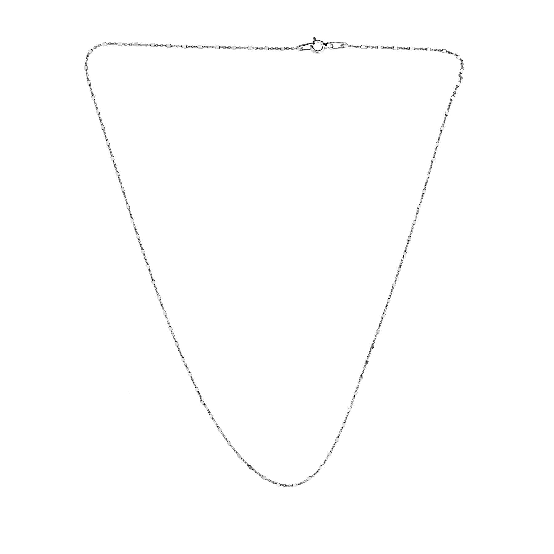 Delicate sterling silver layering necklace featuring a fine 0.8mm chain with evenly spaced 1mm cube accents, embodying minimalist and sculptural contemporary design.