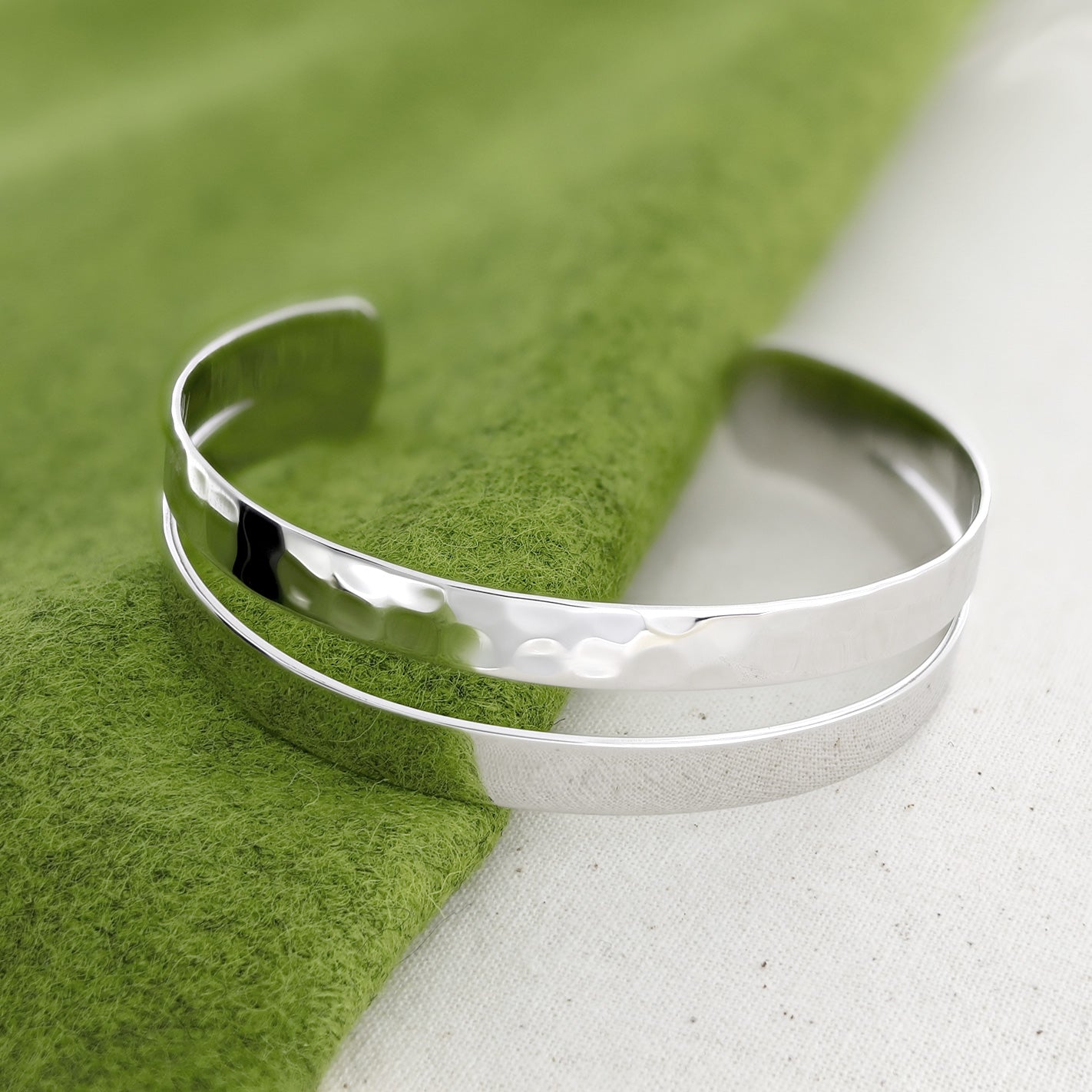Sterling silver cuff bangle featuring a hammered and polished finish with a sleek, sculptural silhouette, exemplifying contemporary British silver jewellery design.