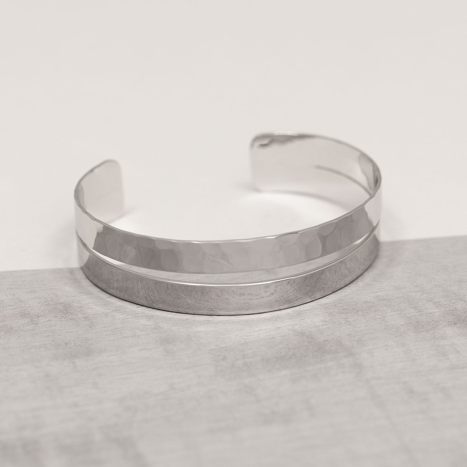 Sterling silver cuff bangle featuring a sleek, polished band paired with a hammered textured strip, showcasing a modern and sculptural design by Azendi.