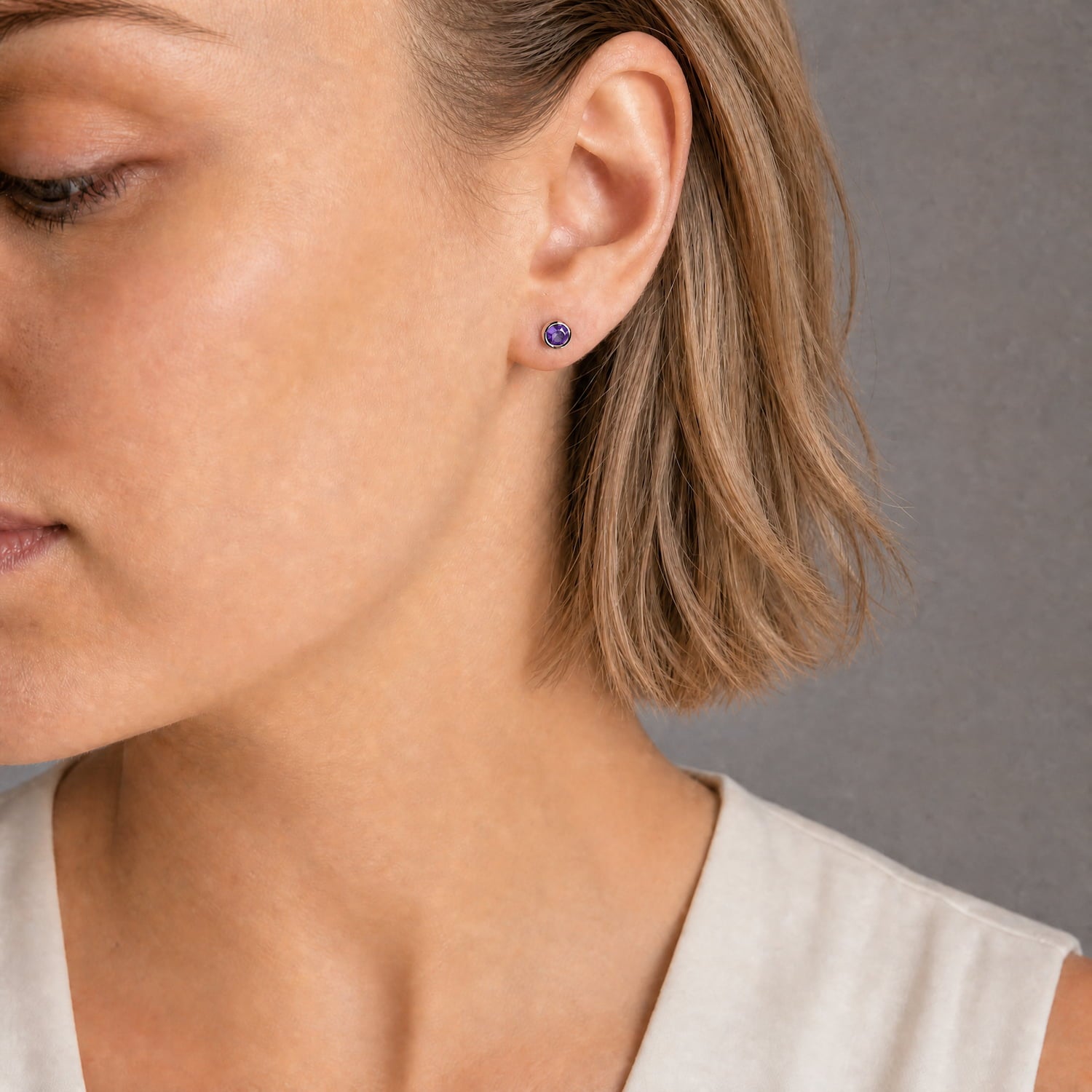Delicate sterling silver stud earrings featuring deep purple amethyst gemstones, exemplifying expert British craftsmanship with a refined and minimalist design.