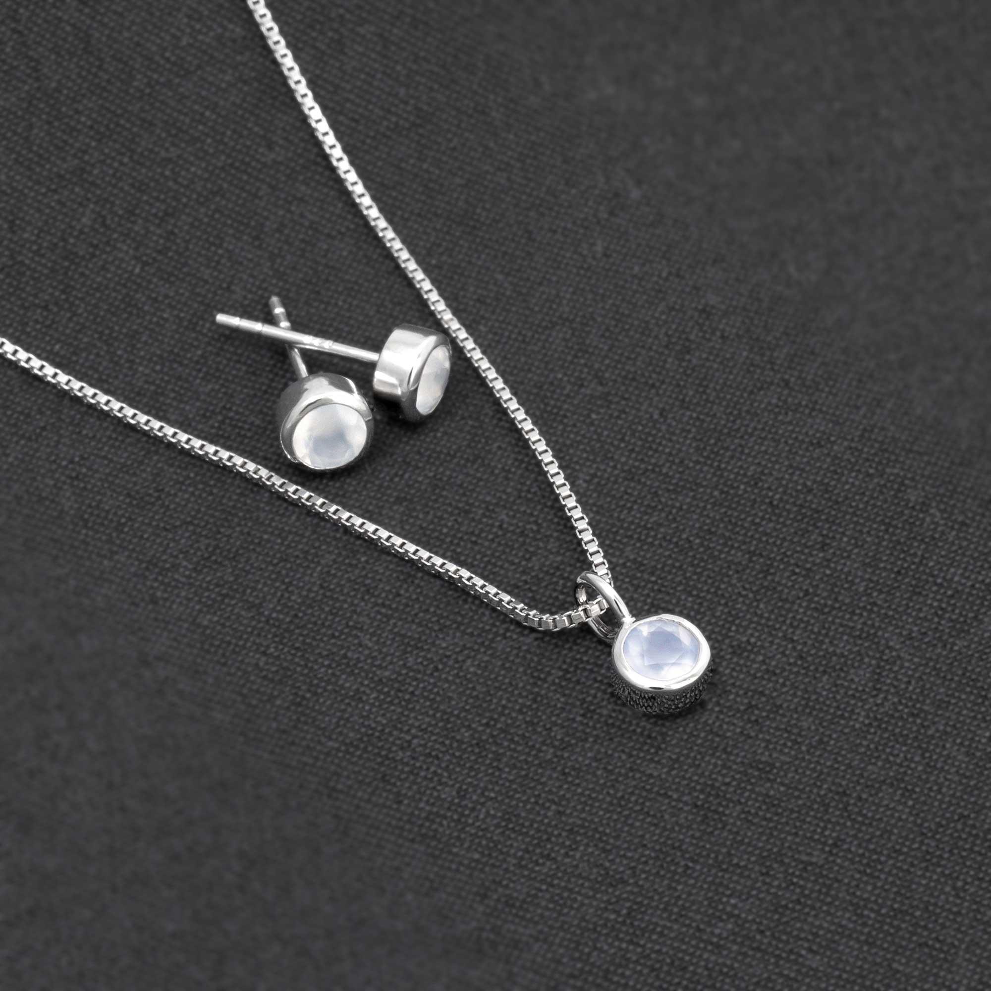 Elegant sterling silver stud earrings set with smooth aqua chalcedony gemstones, paired with a matching pendant on a fine chain, exemplifying expert British craftsmanship.