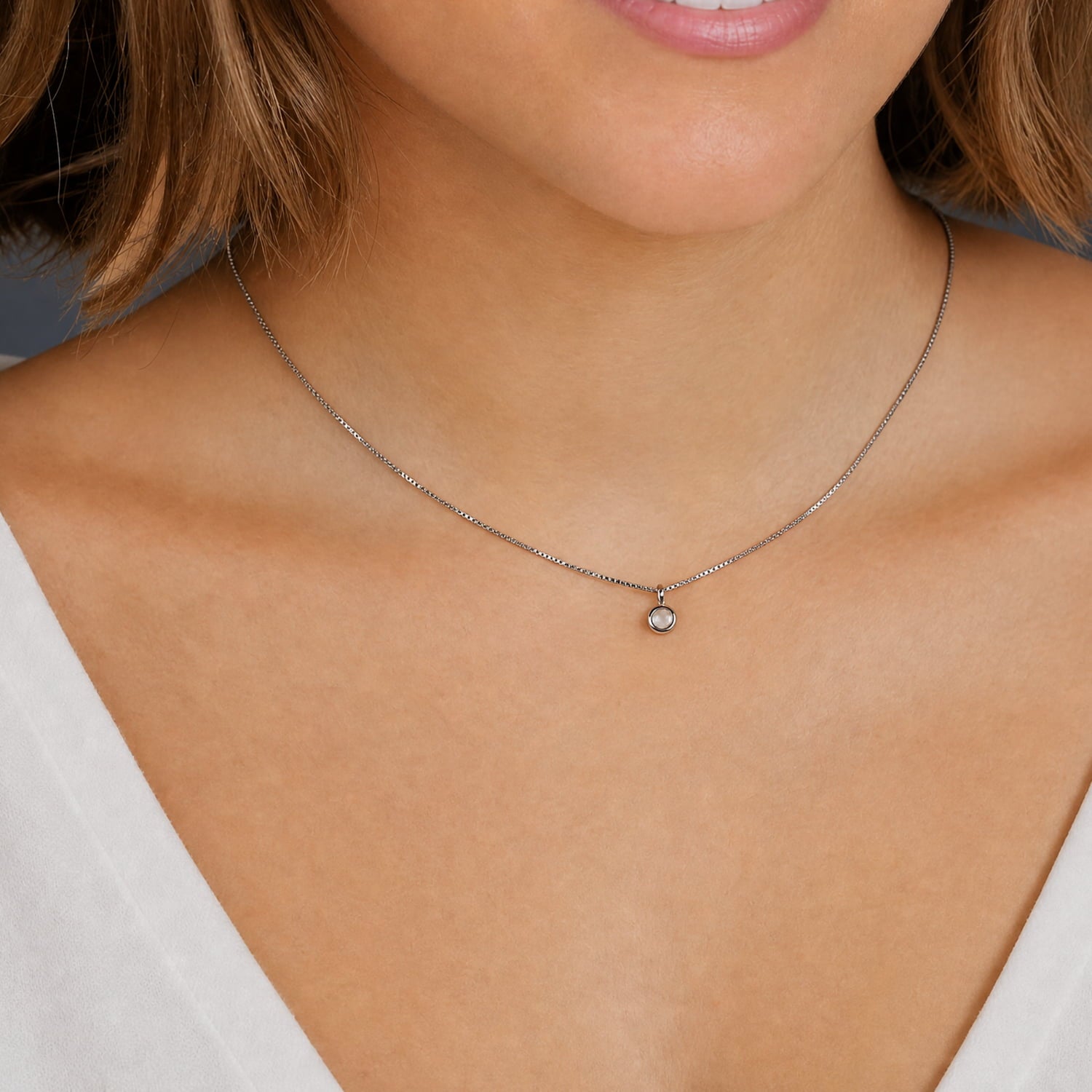 Delicate sterling silver necklace featuring a small aqua chalcedony pendant, highlighting a refined and modern design by an award-winning British jeweller.