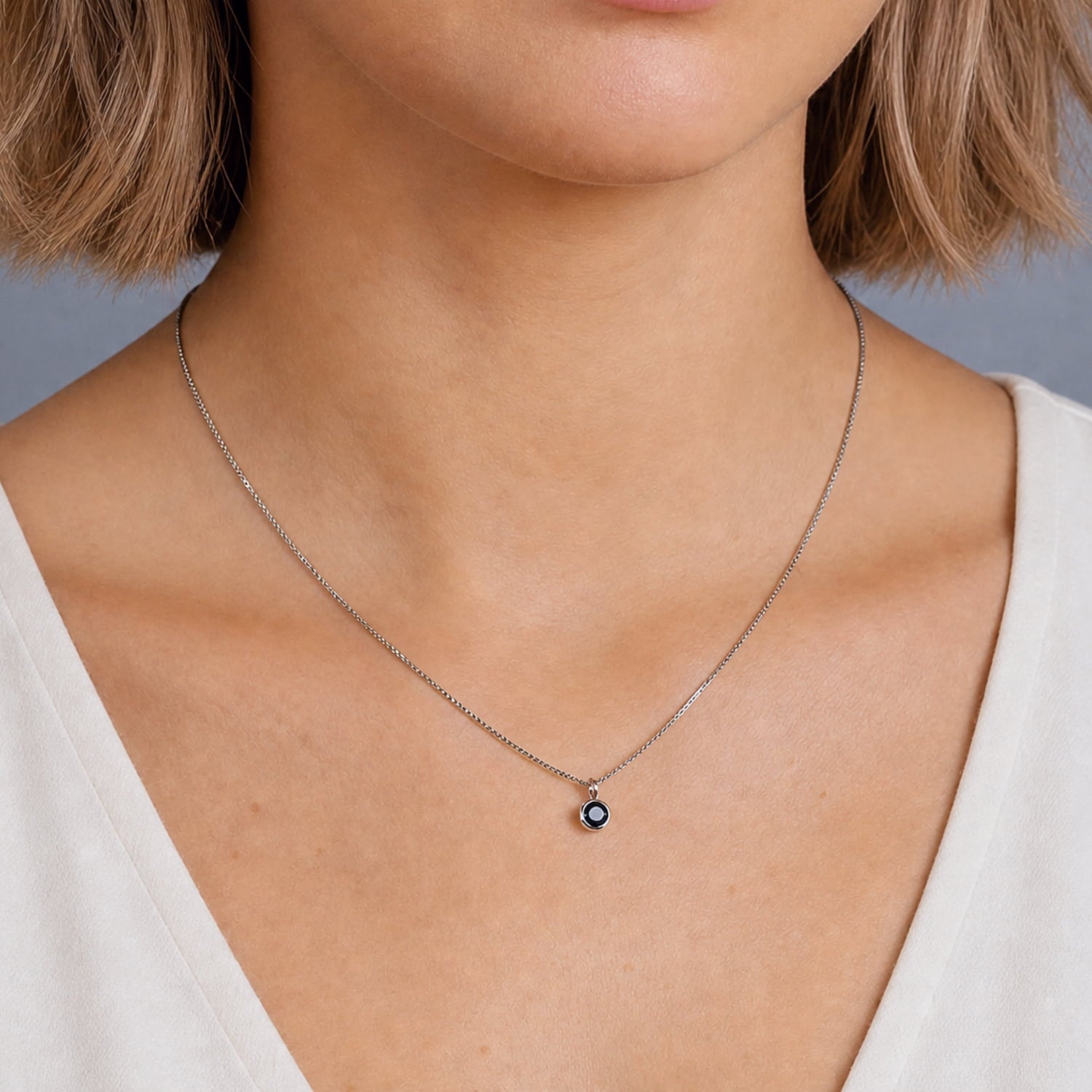 Sterling silver necklace featuring a simple bezel-set deep blue spinel pendant, highlighting expert British craftsmanship and contemporary, elegant design.