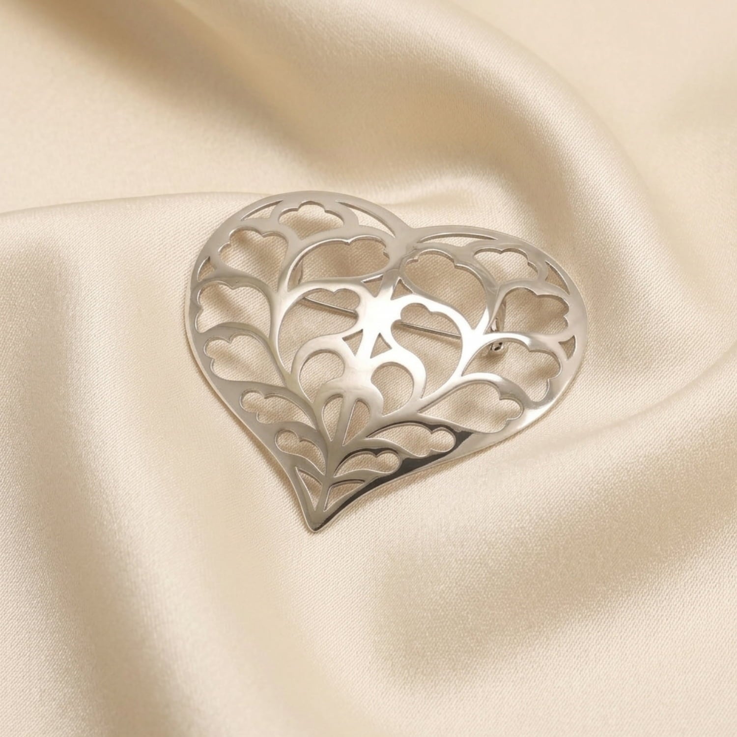 Large sterling silver brooch with an intricate openwork heart design inspired by Yorkshire, displayed on soft textured fabric, showcasing contemporary silver jewellery craftsmanship.