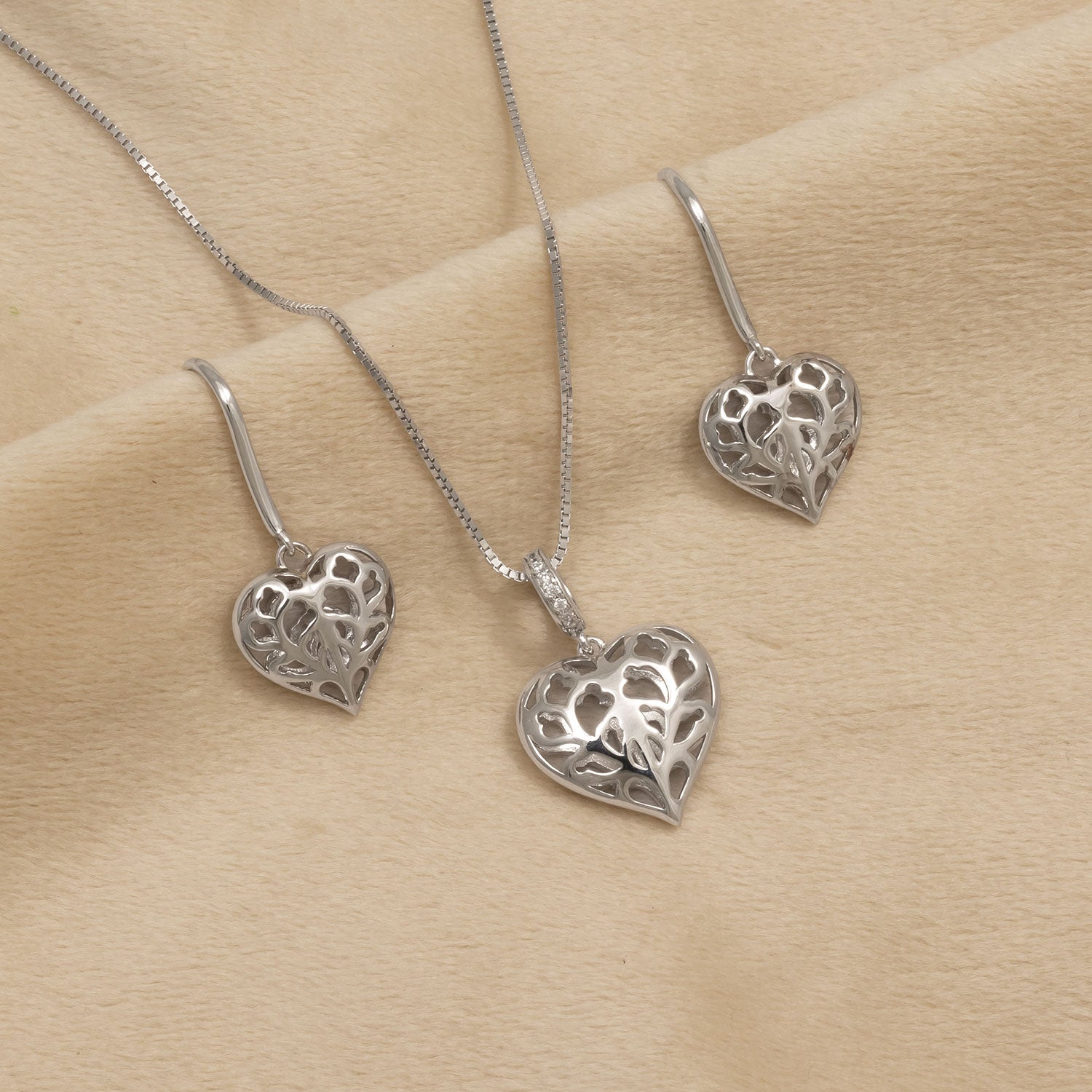 Sterling silver drop earrings and matching pendant featuring delicate openwork hearts with intricate leaf-inspired cut-out patterns on a fine chain.