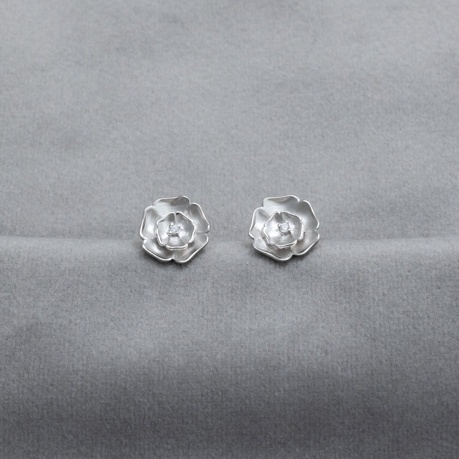 Pair of sterling silver stud earrings designed as frosted Yorkshire roses, featuring a delicate sculptural form that highlights expert British silver jewellery design.