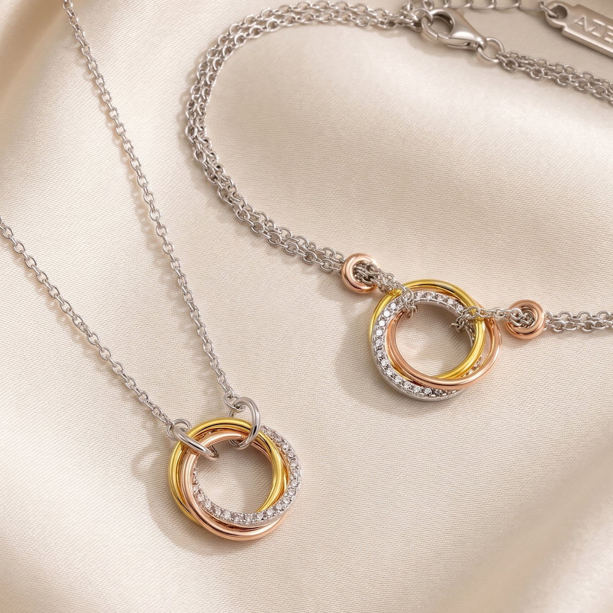 Sterling silver necklace and bracelet set featuring intertwined triple circles in mixed metals with pavé detailing, showcasing a modern and sculptural design by Azendi.