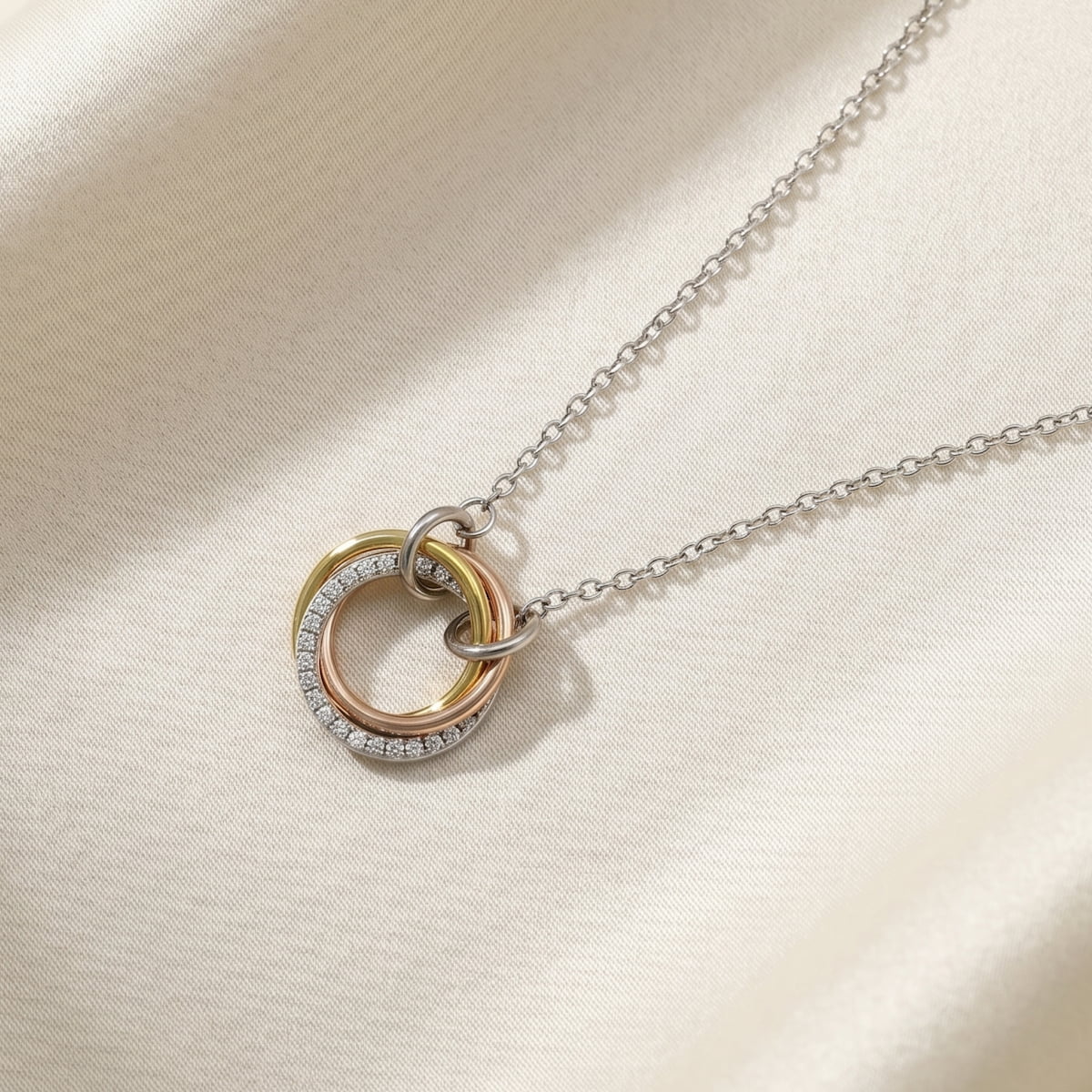 Sterling silver necklace featuring three interlocking circles in silver, rose, and gold vermeil, with pavé detailing on the silver ring for a sculptural, contemporary design.