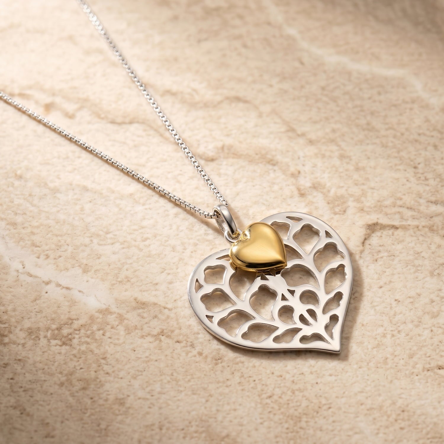 Sterling silver heart pendant with an openwork Yorkshire-inspired design, accented by a small yellow gold vermeil heart, suspended on a delicate silver chain.