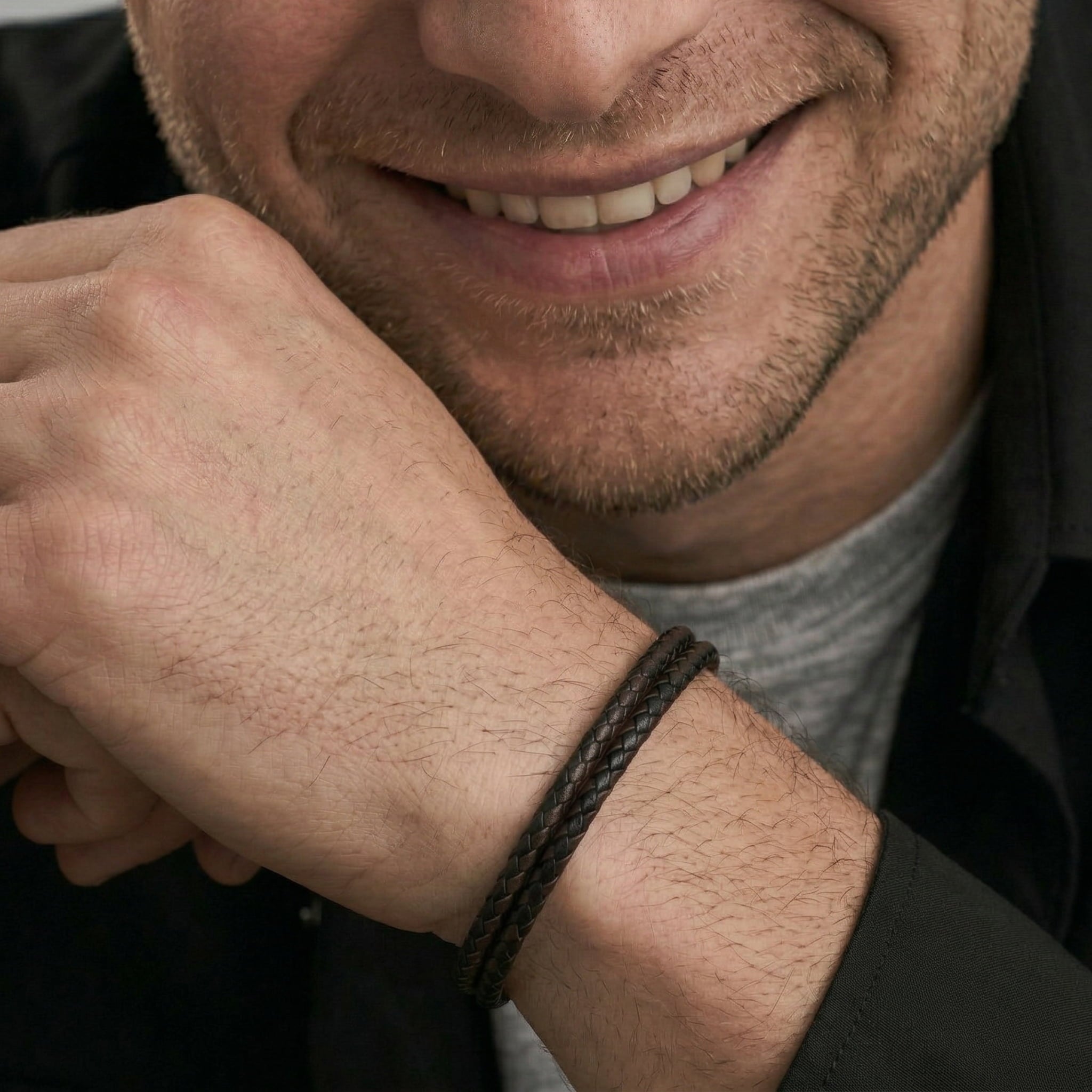Close-up of a man wearing a leather bracelet with a blurred background
