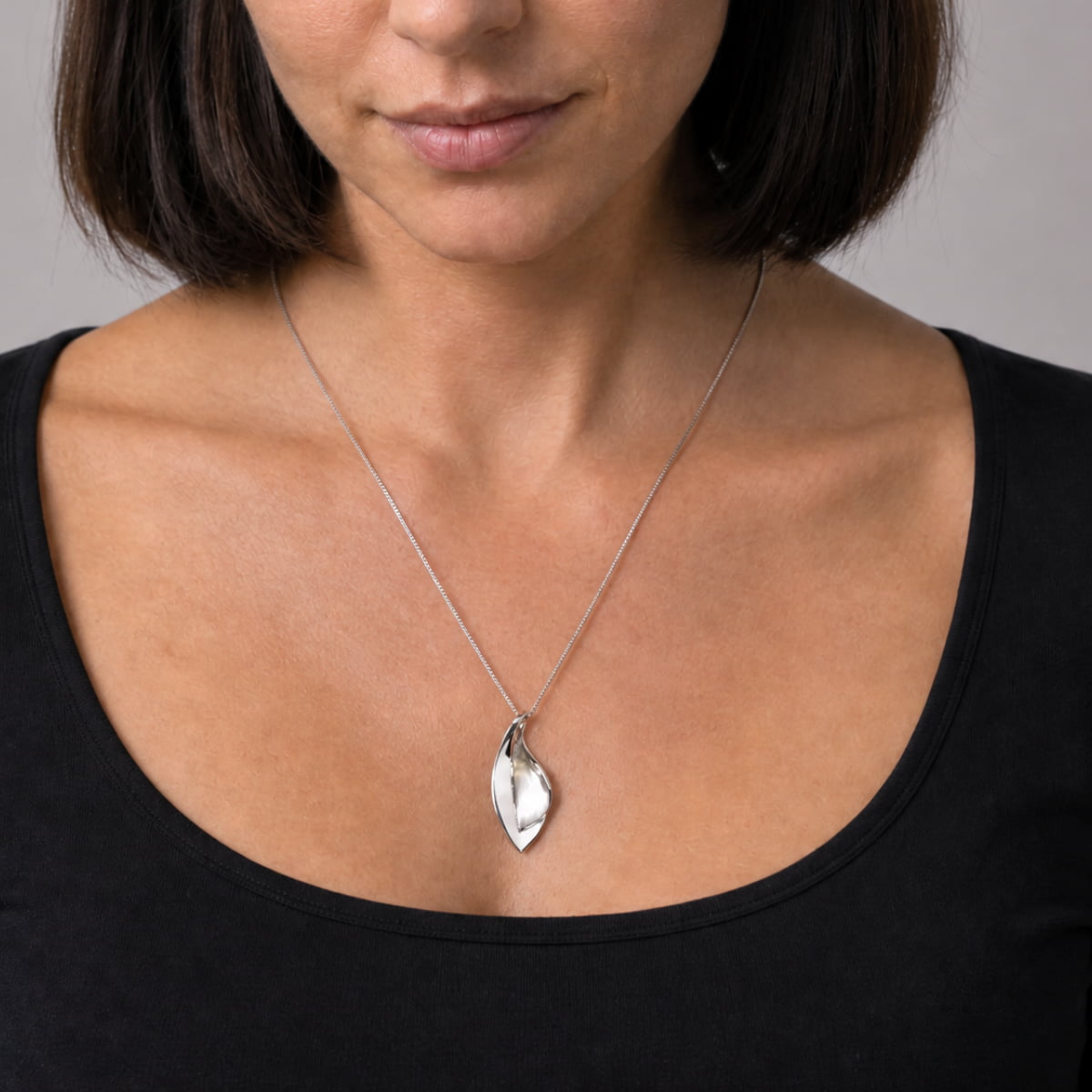 Sleek sterling silver pendant featuring a double leaf design with a smooth, polished finish, suspended from a delicate chain for refined contemporary elegance.