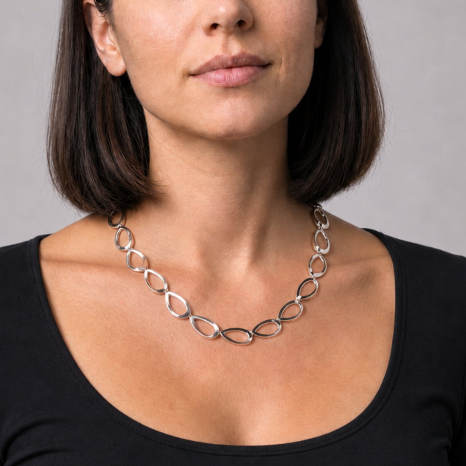 Polished sterling silver necklace featuring a series of smooth, teardrop-shaped links connected to form a sculptural chain, exemplifying refined contemporary silver jewellery.