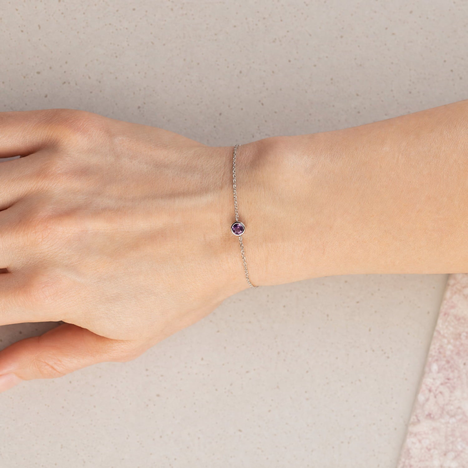 Delicate sterling silver bracelet featuring a single amethyst stone with a fine adjustable chain, embodying elegant British craftsmanship by Azendi.